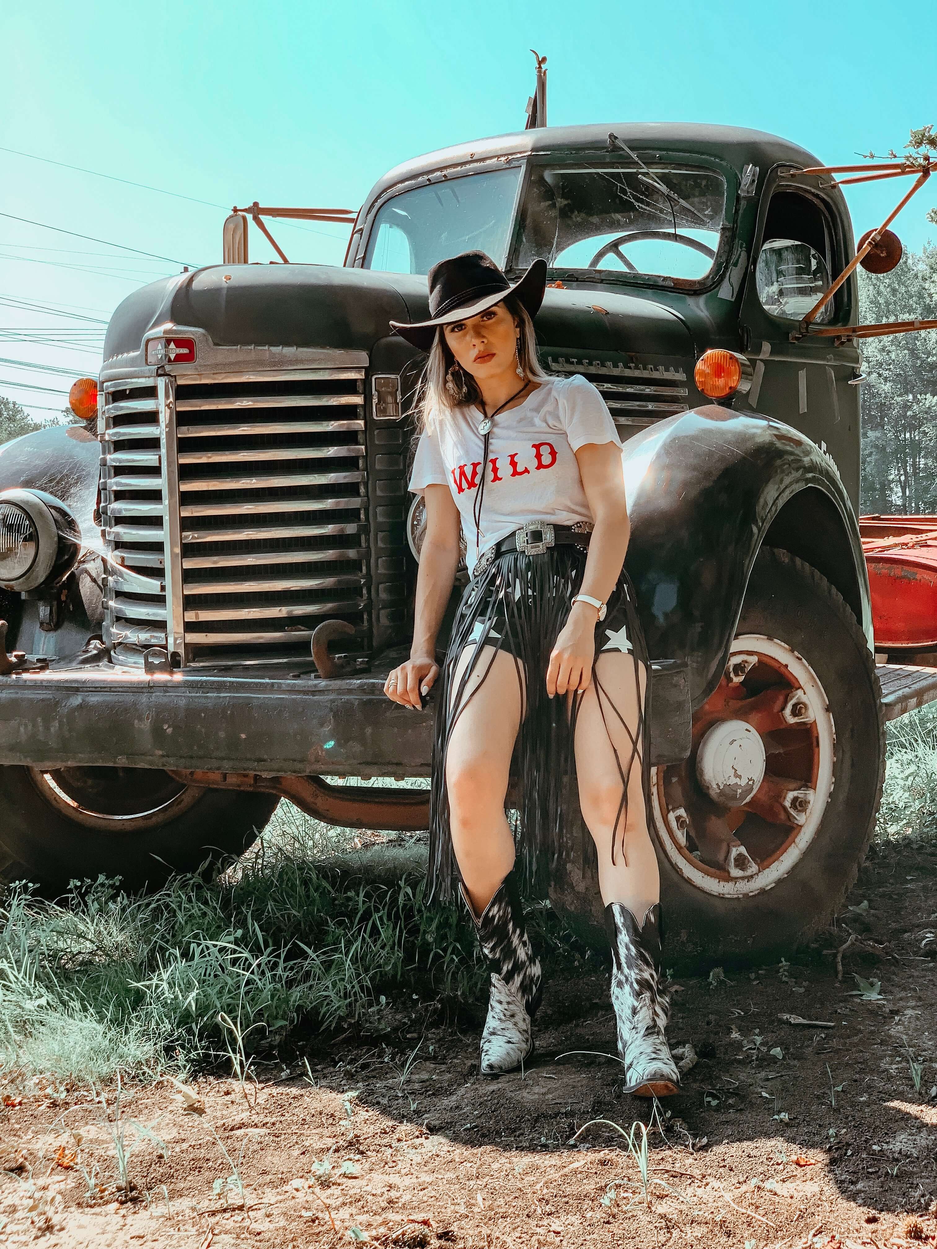 Woman wearing Carmen mid-calf cowhide boots in the ranch