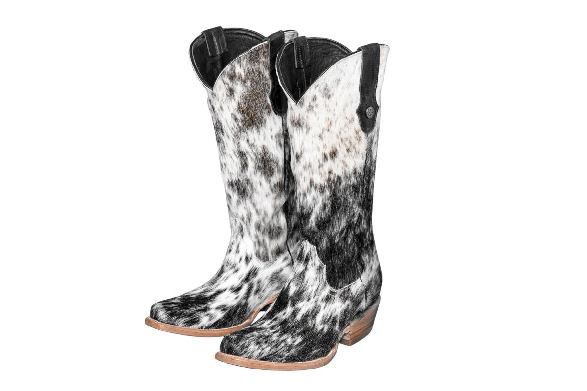 Black and white cowhide boots on a white background