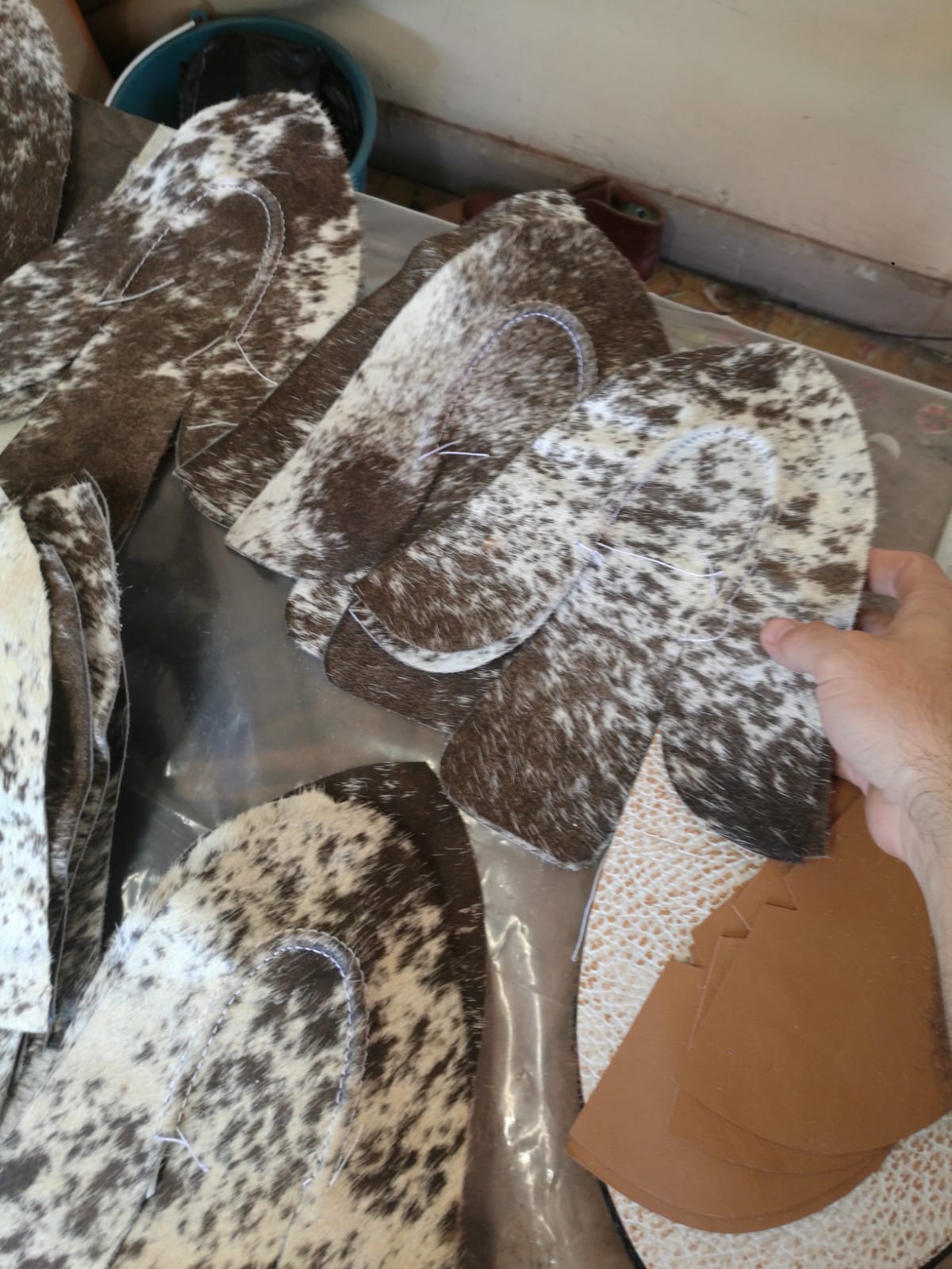 cowhide boots behind the scenes, person cutting molds 