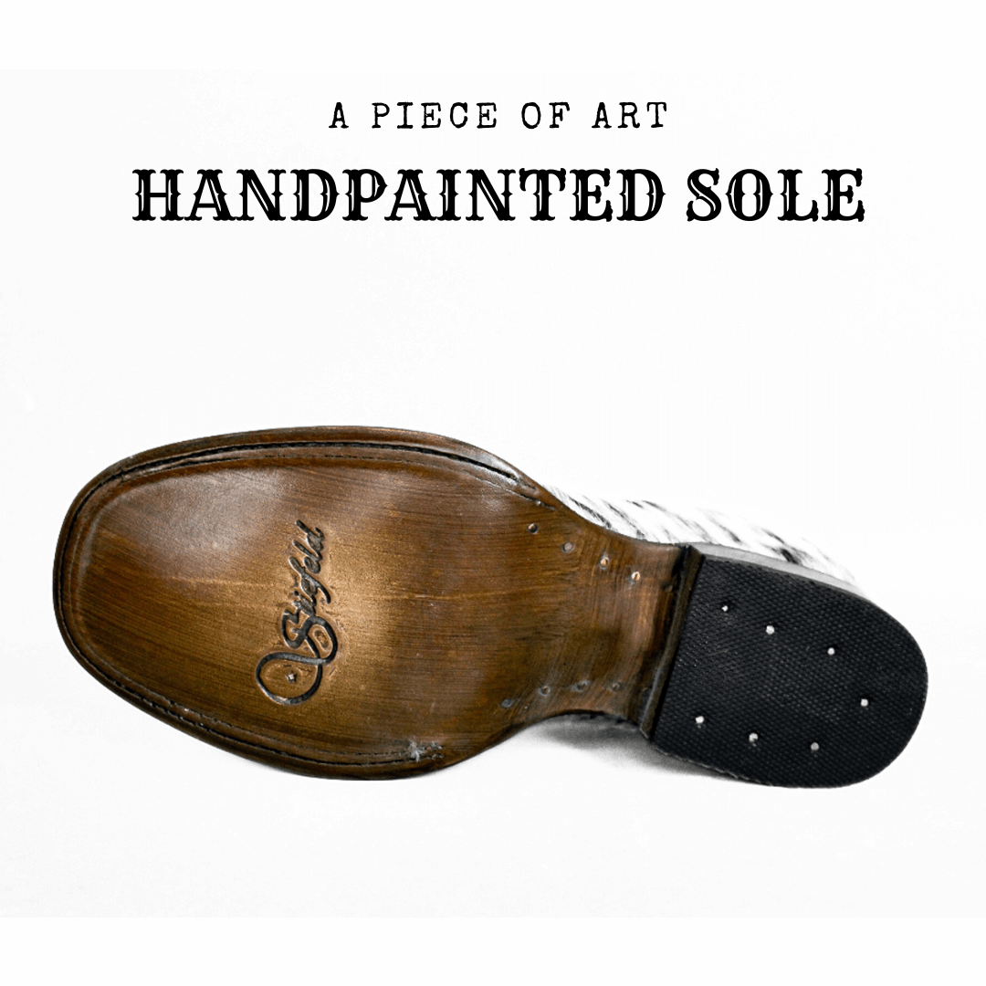 Artisan applying hand-painted finish to the leather sole of a boot