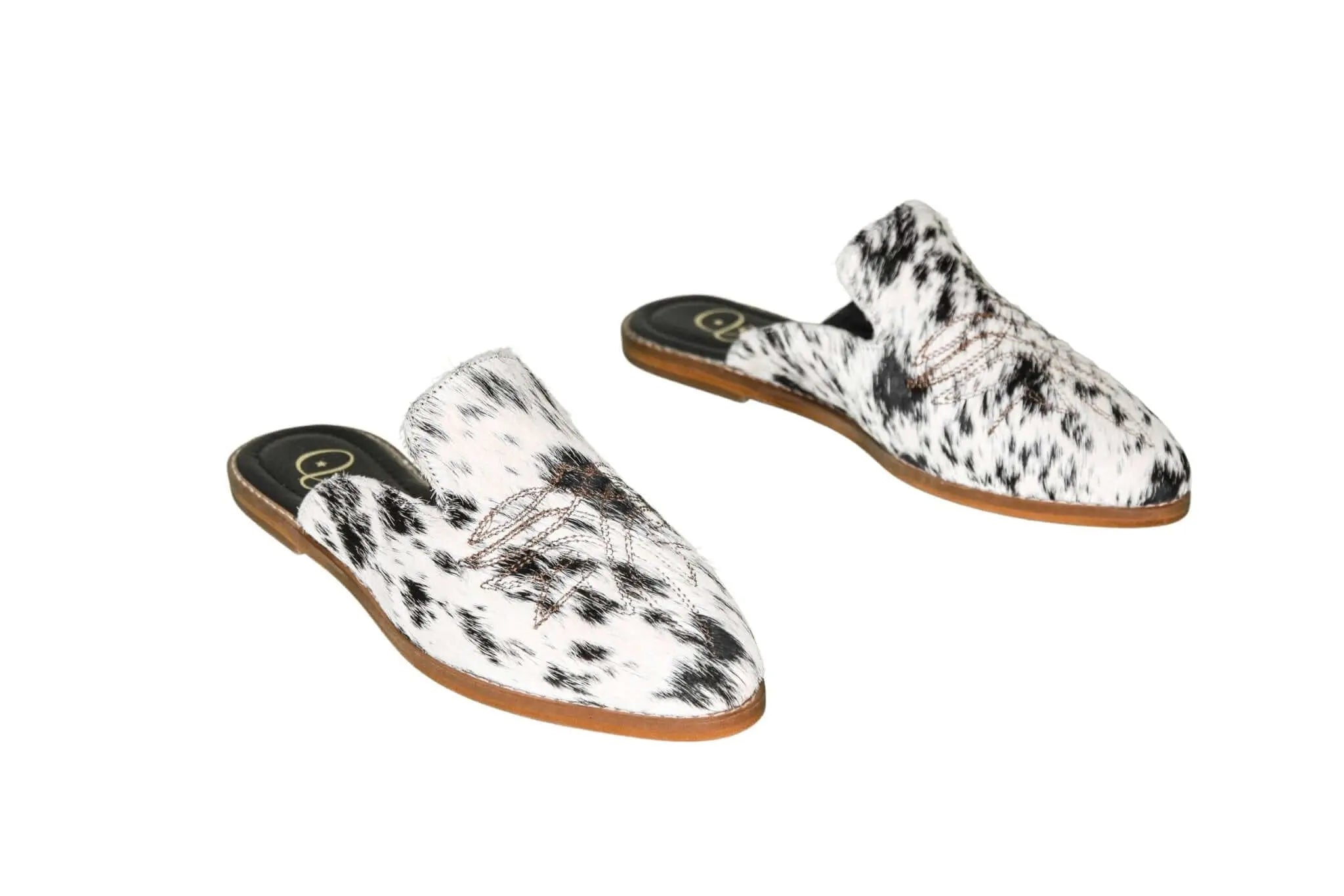 black and white hair-on-hide mules with leather sole
